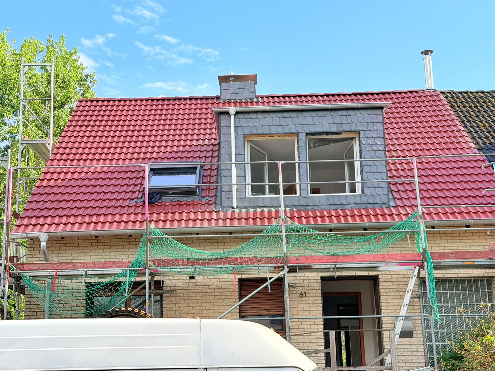 Neu eingedecktes rotes Dach mit Gaube und Dachfenster